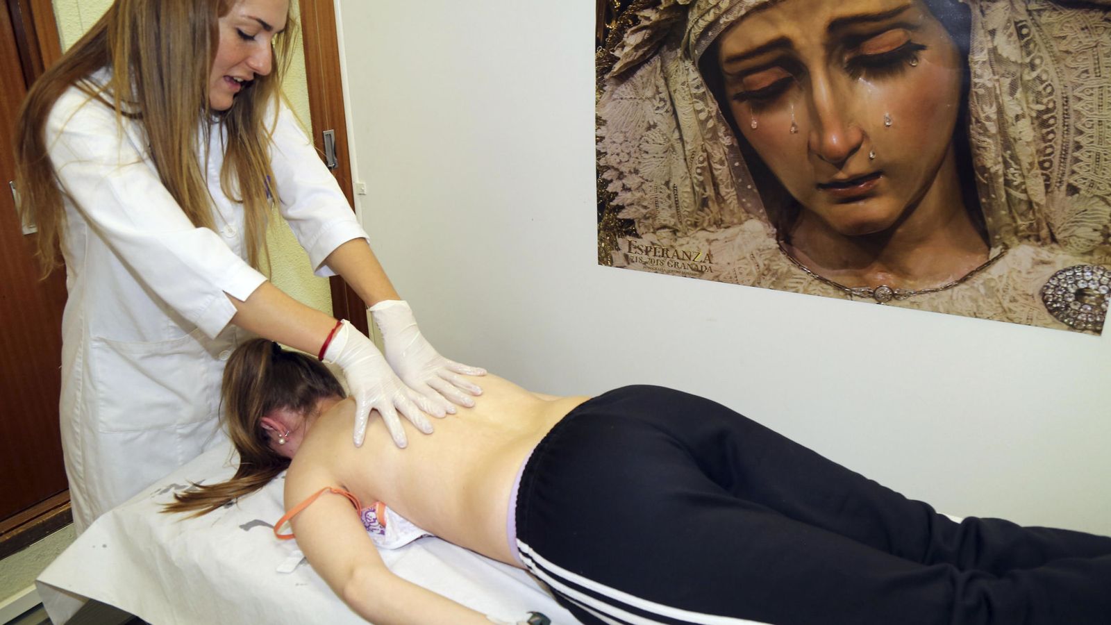 Foto: Una fisioterapeuta da masajes a una costalera en el Centro de Atención al Costalero (CEACO) en Granada. (EFE)