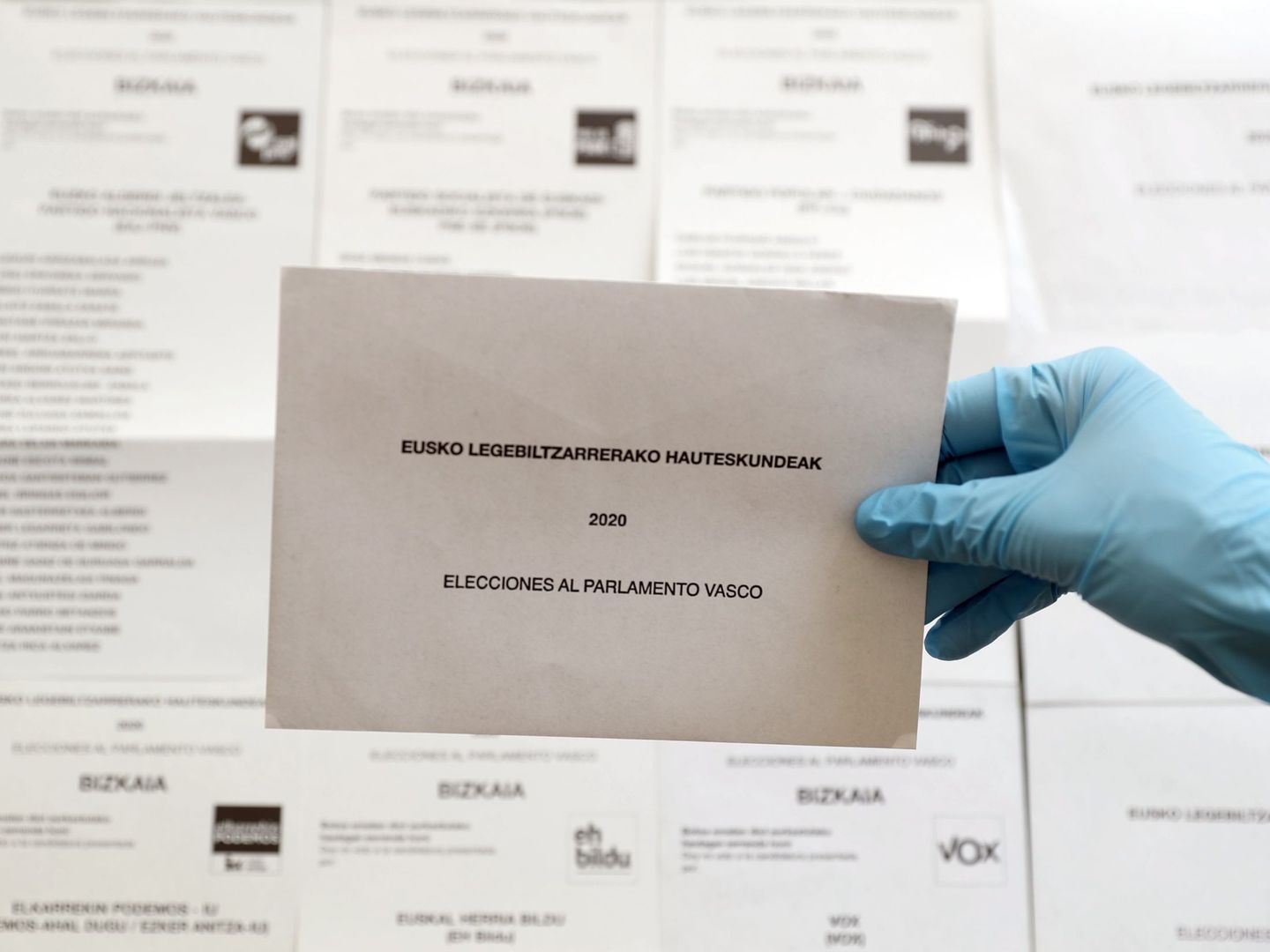 Un sobre para depositar el voto junto a diferentes opciones políticas al Parlamento Vasco. (EFE)