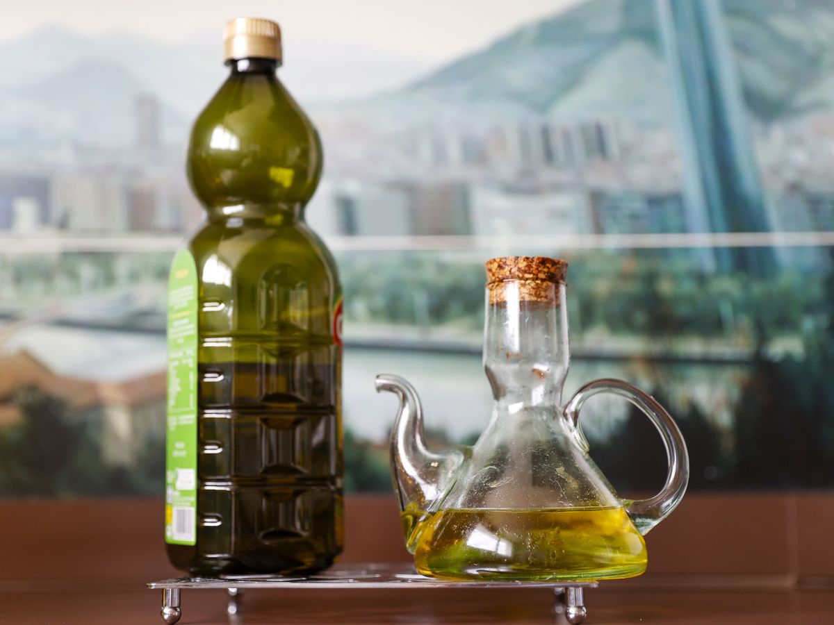 Foto: Una botella y una aceitera con aceite de oliva virgen. (EFE/Luis Tejado)