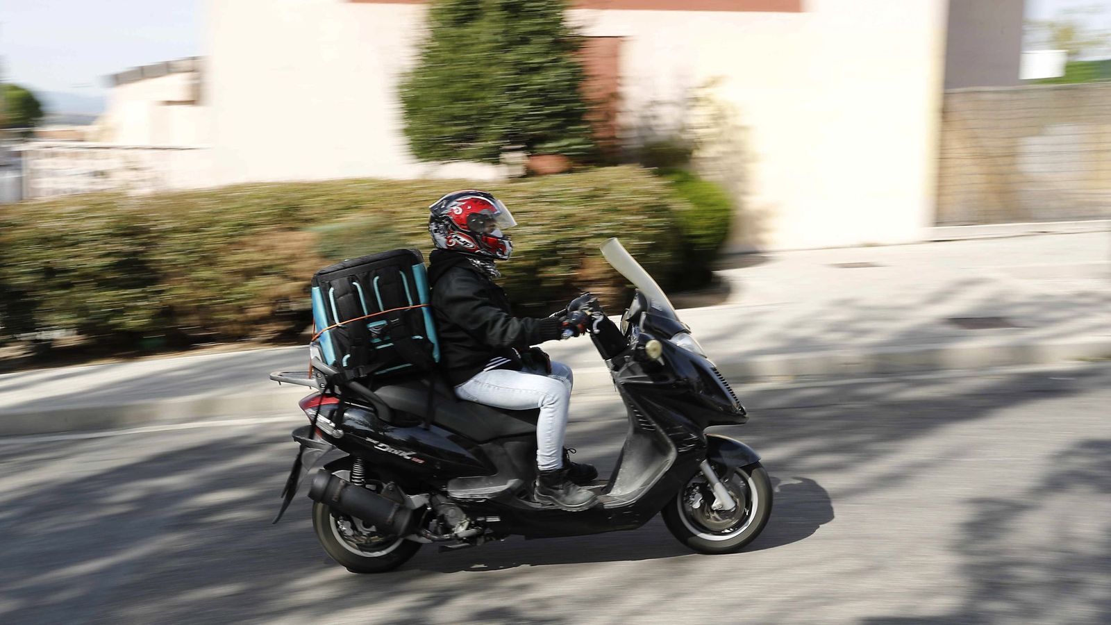 Un repartidor trabaja con su moto en Madrid. (EFE)