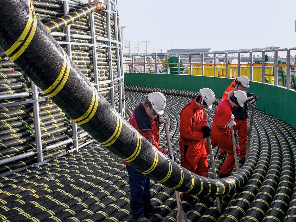 Foto: Operarios manipulan en una imagen de archivo un cable de fibra óptica submarino. (EFE)