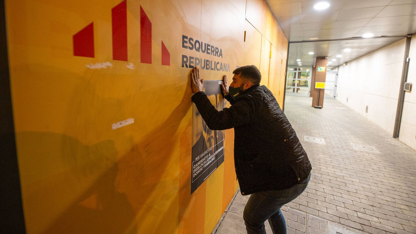 Un activista de Solidaridad pega un cartel en la sede de ERC en Barcelona. (D.B.)