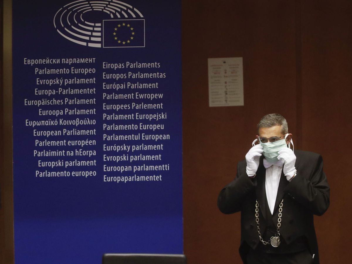 Foto: Un trabajador del Europarlamento luce una mascarilla durante una votación de la Cámara. (EFE)