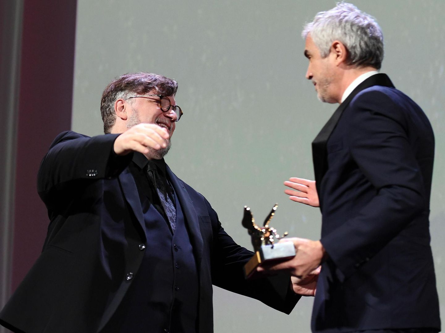 Alfonso Cuaron abraza a Guillermo del Toro tras recibir el galardón. (EFE)