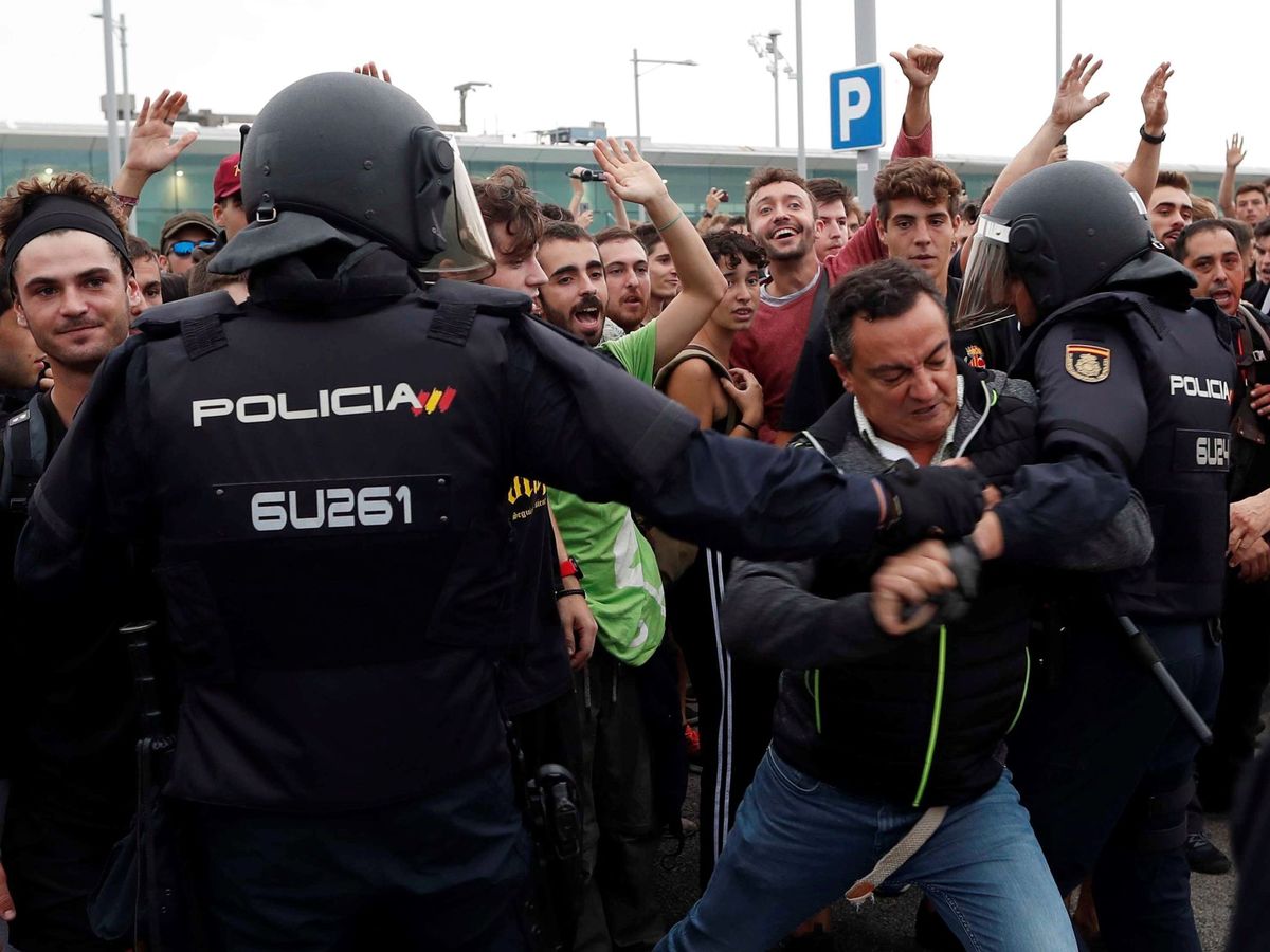 Foto: Un manifestante intenta romper el cordón policial en el Aeropuerto de El Prat. (EFE)