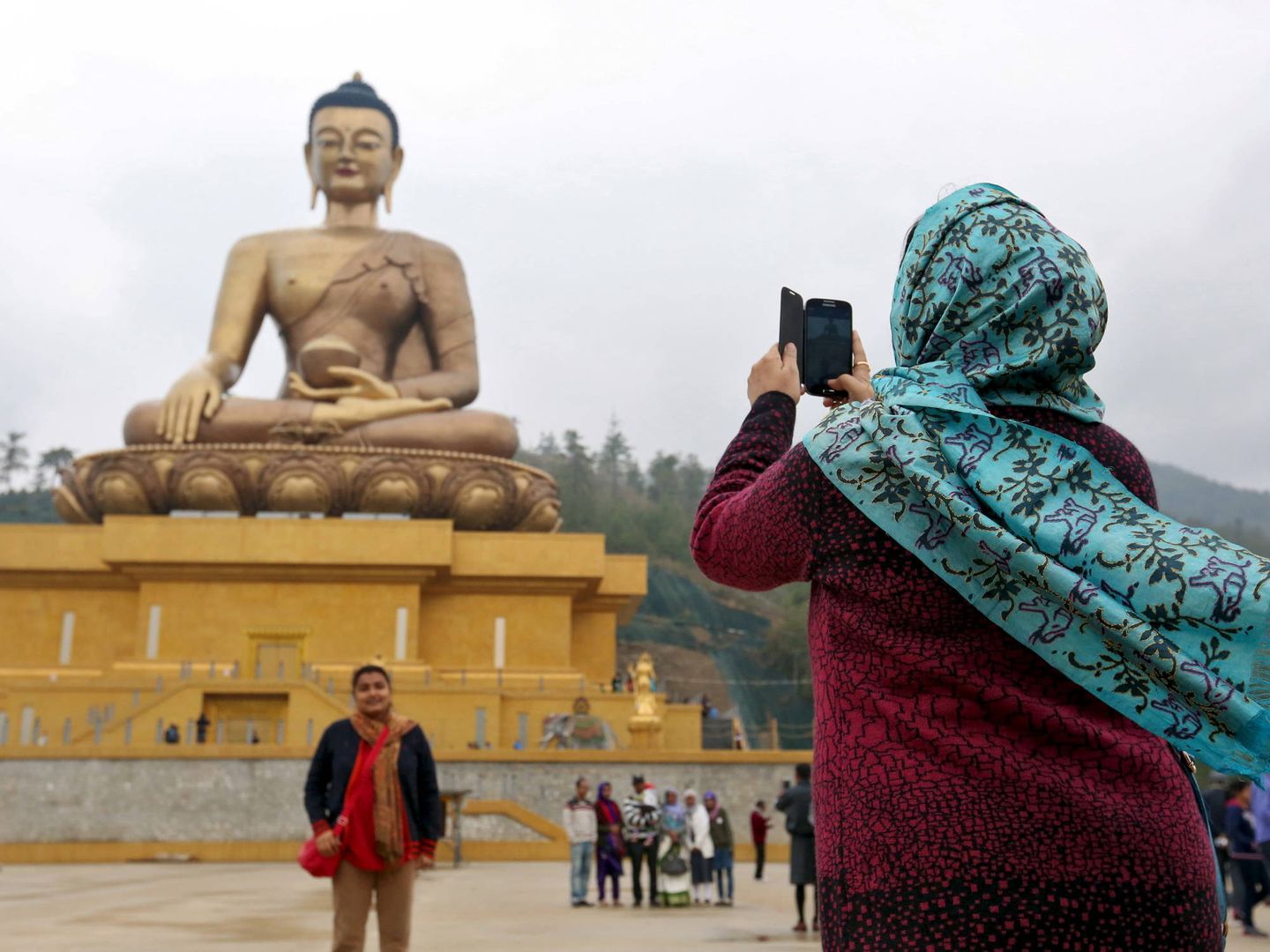 Turistas ante la estatua del buda Dordenma en la capital de Bután, Thimphu (Reuters)