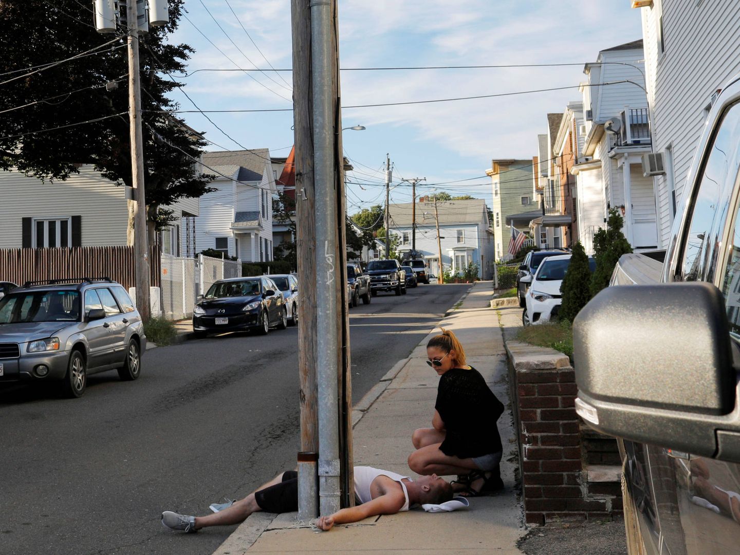 Una joven atiende a su novio durante una sobredosis de opioides en Everett, Massachusetts, en agosto de 2017. (Reuters)