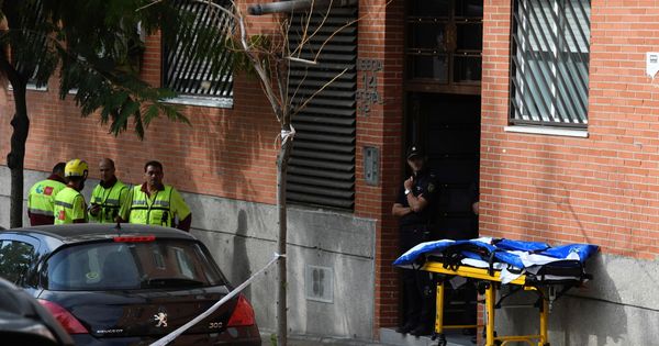 Foto: Agentes de la Policía Nacional y personal sanitario vigilan este lunes la entrada del piso en Leganés (Madrid). (EFE)