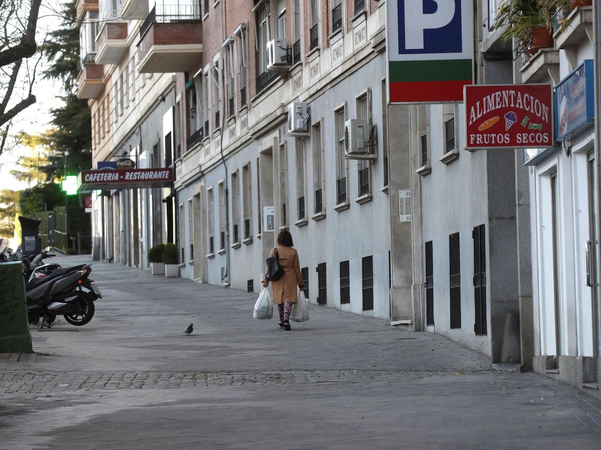 Foto: Una mujer camina por una calle de Madrid, vacía por el confinamiento. (EFE)
