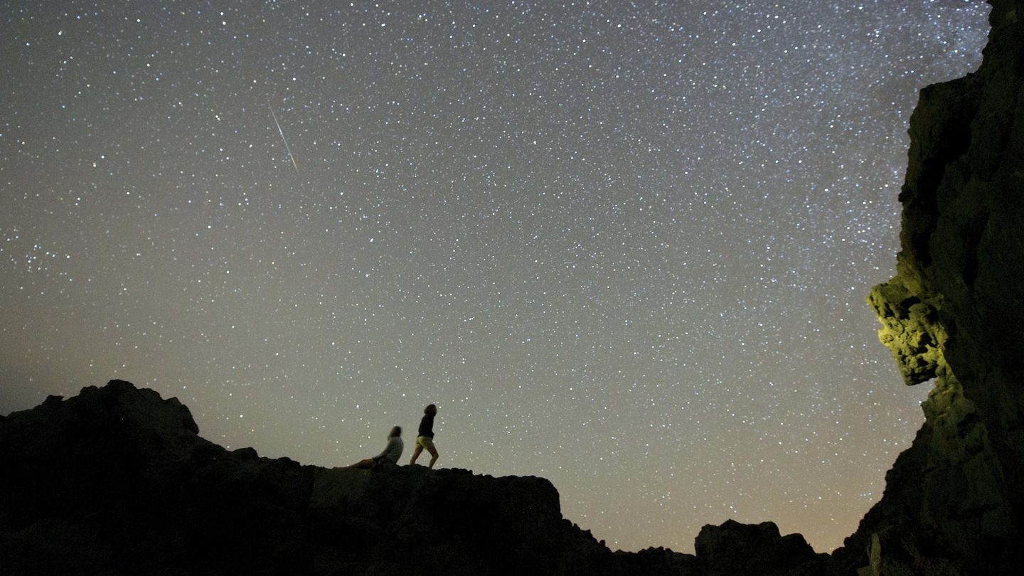 Dos personas observan la tradicional lluvia de estrellas o delta acuáridas de julio en la 'Playa del Valle' en el municipio de Betancuria, Fuerteventura. EFE/CARLOS DE SAA