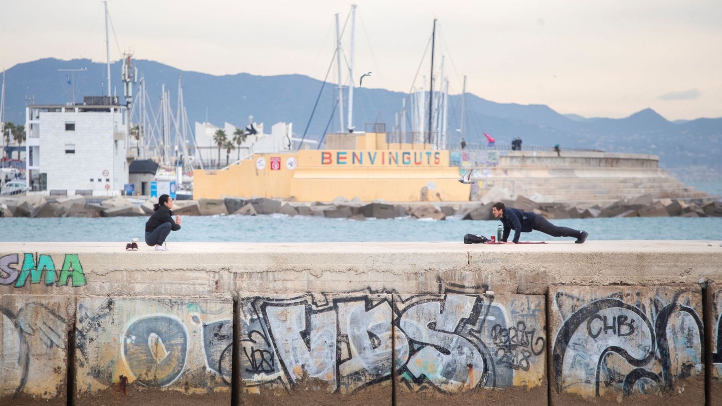 Dos personas hacen ejercicio en la playa de Barcelona. (EFE)