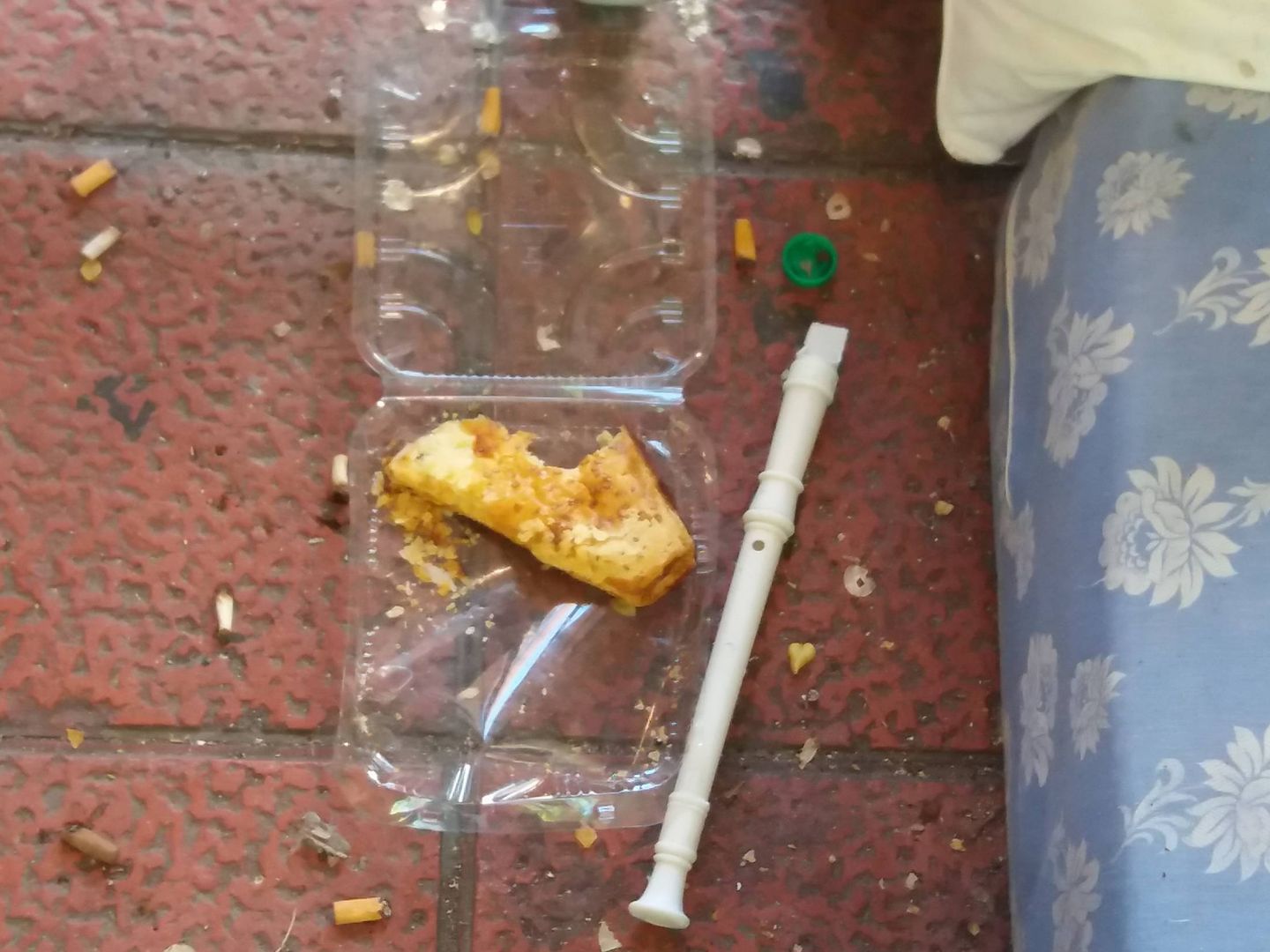 Restos de comida guardada en una bandeja de plástico y una flauta. (Á. Caballero)