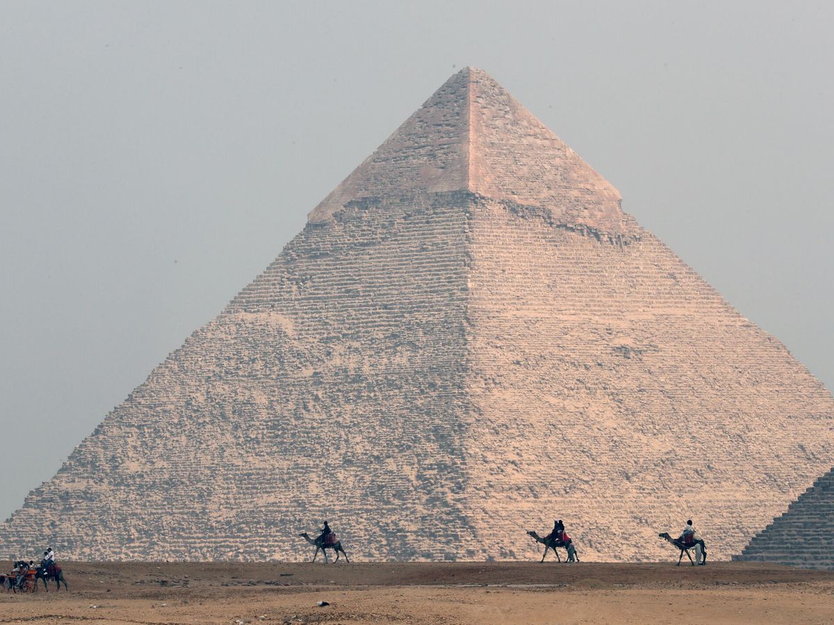 Foto: Turistas pasean en camellos frente a las Pirámides de Giza (EFE/KHALED ELFIQI)