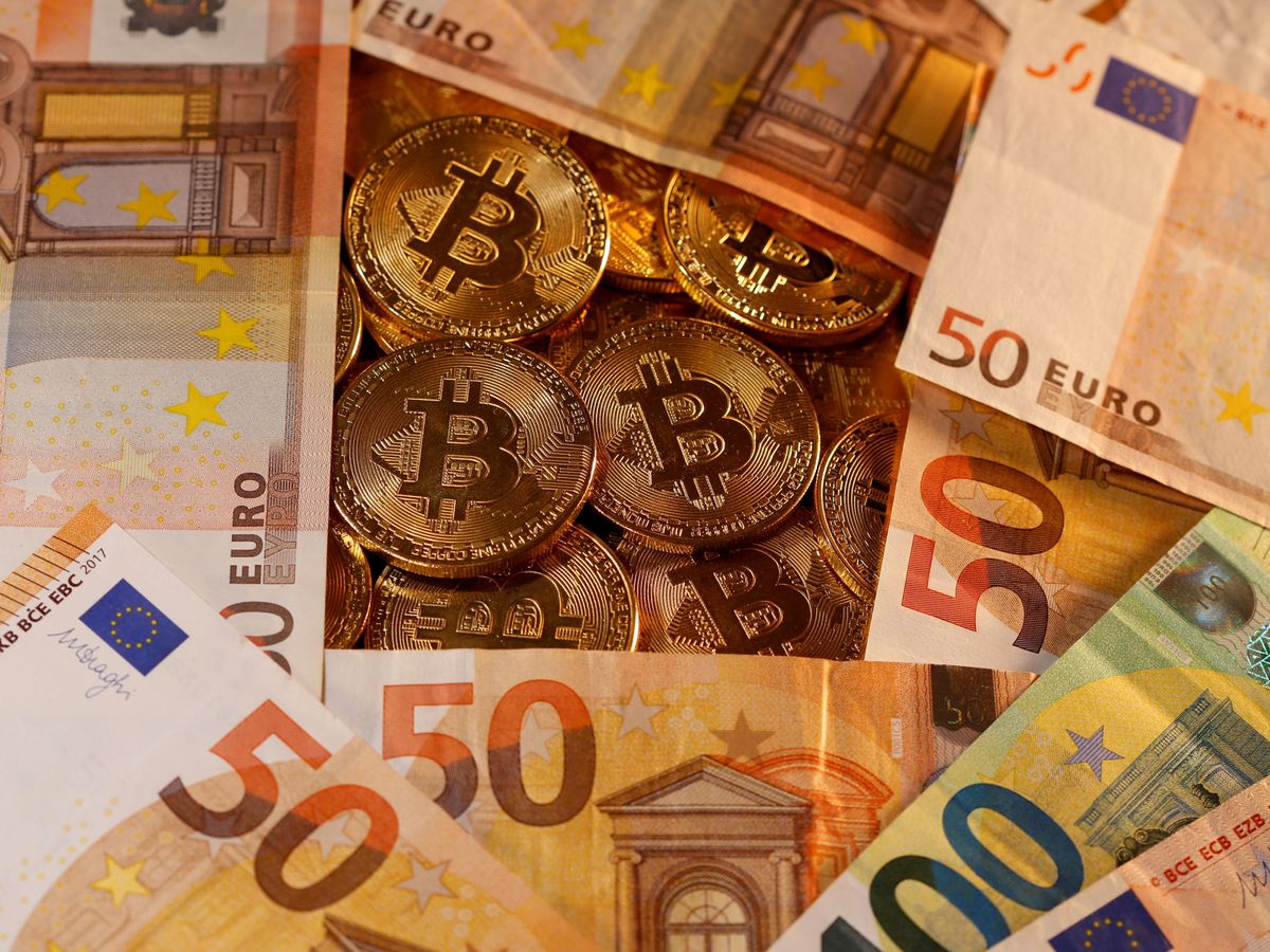 Foto: Monedas de bitcoin entre euros. (Reuters)