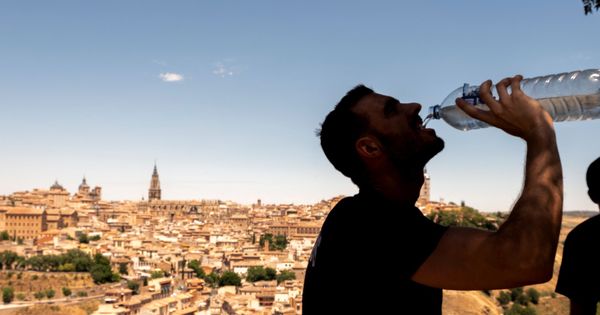 Foto: Un hombre bebe agua bajo las altas temperaturas en Toledo. (EFE)