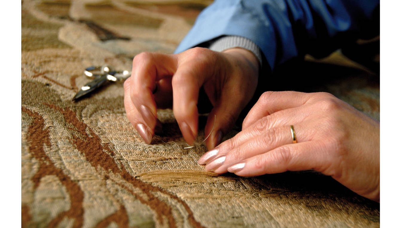 Detalle del proceso de restauración de un tapiz.
