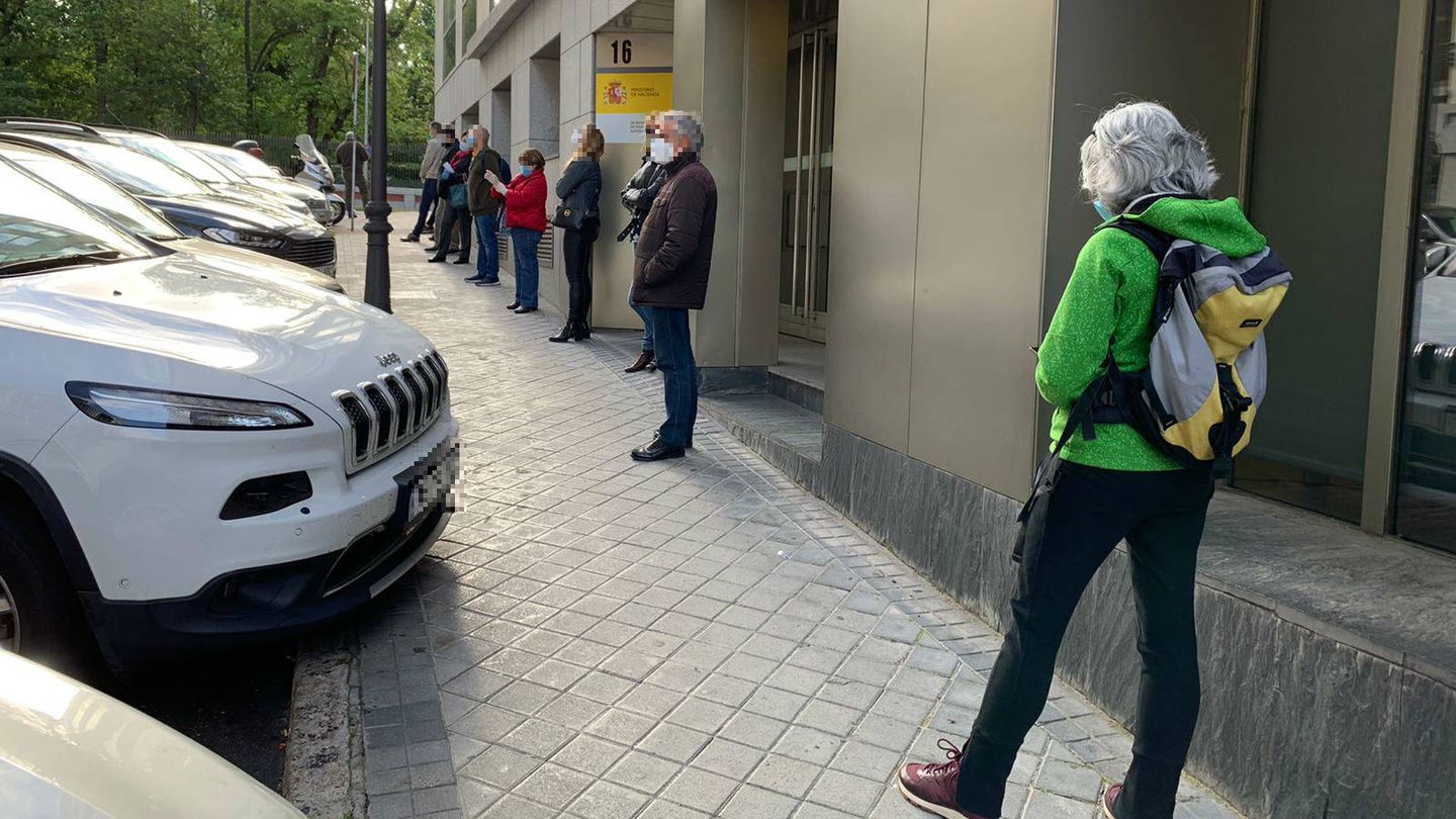 Unas 40 personas hacen cola frente a la clínica Megalab, en Madrid, para hacerse el test de coronavirus.