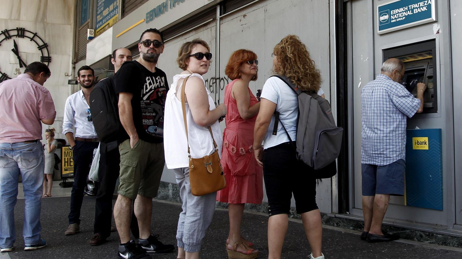 Foto: Atenienses hacen cola para retirar dinero de un cajero automático. (Efe) 
