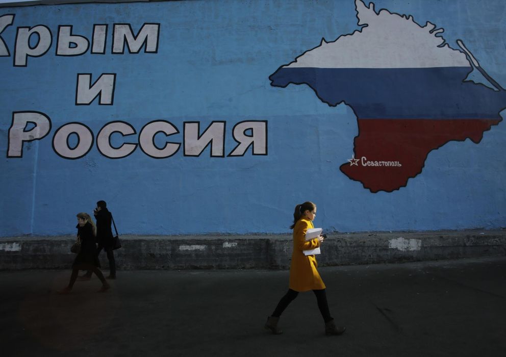 Foto: Una mujer pasa ante un mural que muestra el mapa de Crimea adornado con los colores de la bandera rusa en Moscú. (Reuters)