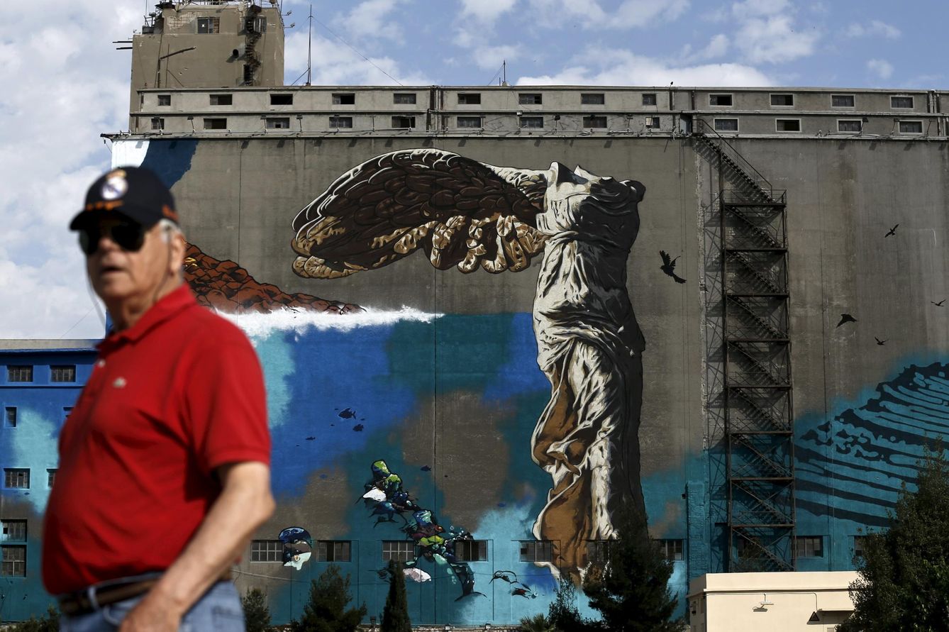 Un hombre pasa ante una pintada que ridiculiza la victoria de samotracia, en el puerto del Pireo, cerca de Atenas (Reuters).