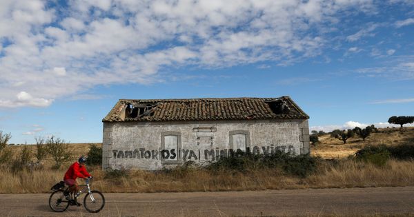 Foto: Un ciclista pasa por delante de un graffiti de protesta contra la mina de Berkeley Energía en Retortillo (Salamanca). (Foto: Reuters)