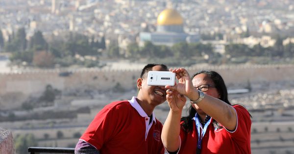 Foto: Unos turistas se hacen un selfie frente a la Ciudad Vieja de Jerusalén, el 10 de diciembre de 2017. (Reuters)