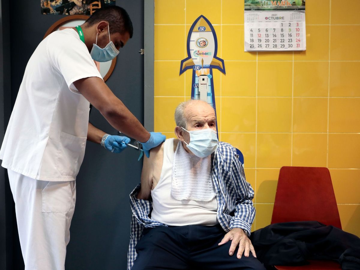 Foto: Un hombre recibe la dosis de refuerzo de covid- y la vacuna de la gripe. (Ana Escobar/EFE)