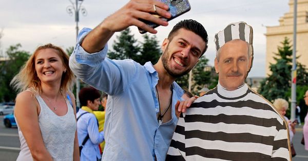Foto: Dos personas haciéndose un selfi con una imagen de cartón de Liviu Dragnea vestido de preso. (EFE)