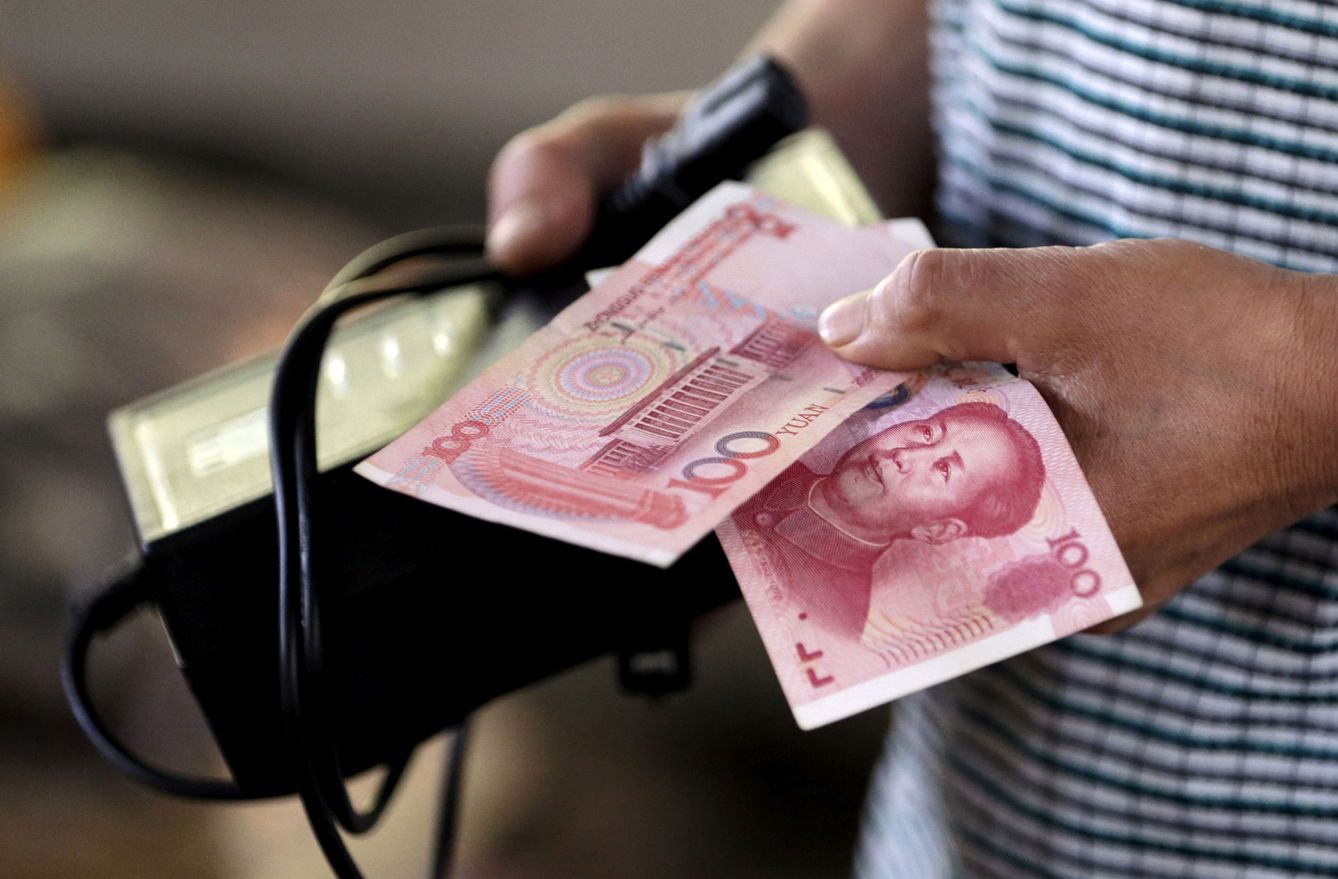 Una persona con 100 yuanes en un mercado de Pekín, China. (Reuters)