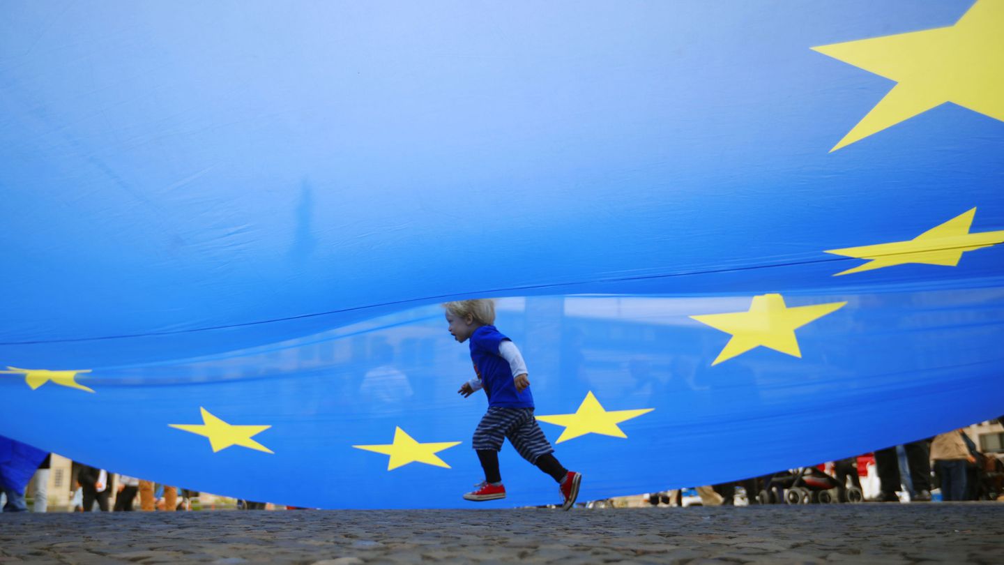 Un niño pasa bajo una bandera europea durante una manifestación en Berlín. (Reuters)