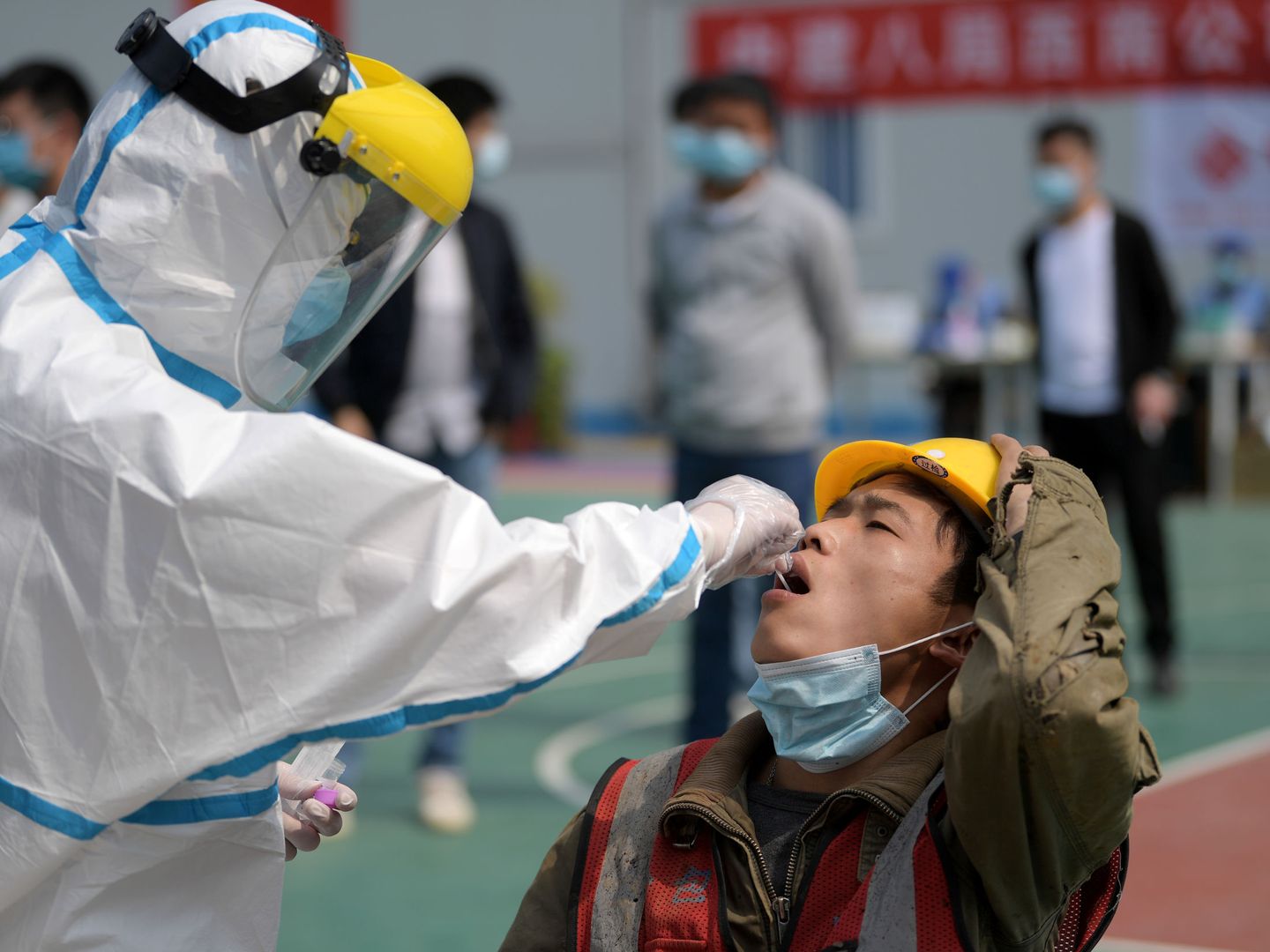 Un sanitario hace un test a un trabajador en Wuhan. (Reuters)