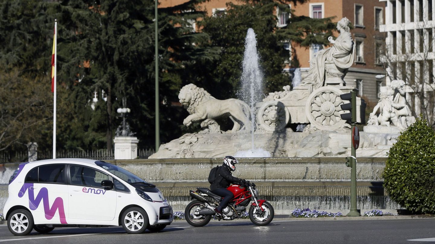 Un coche de alquiler eléctrico de cuatro plazas de la empresa Emov, a su paso por la fuente de Cibeles (Madrid). (EFE)