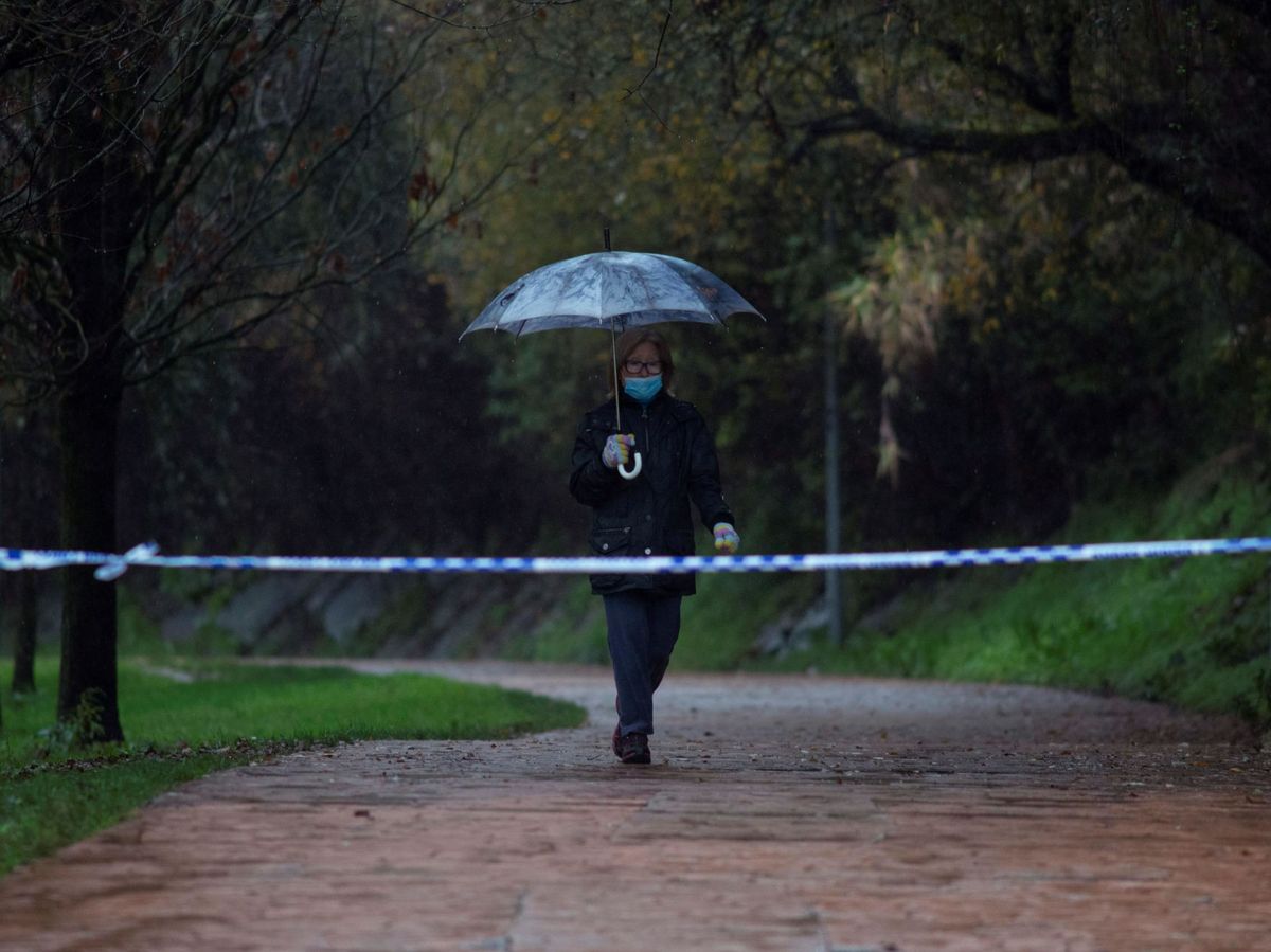 Foto: Una mujer con paraguas camina por una zona fluvial en Galicia. (EFE)
