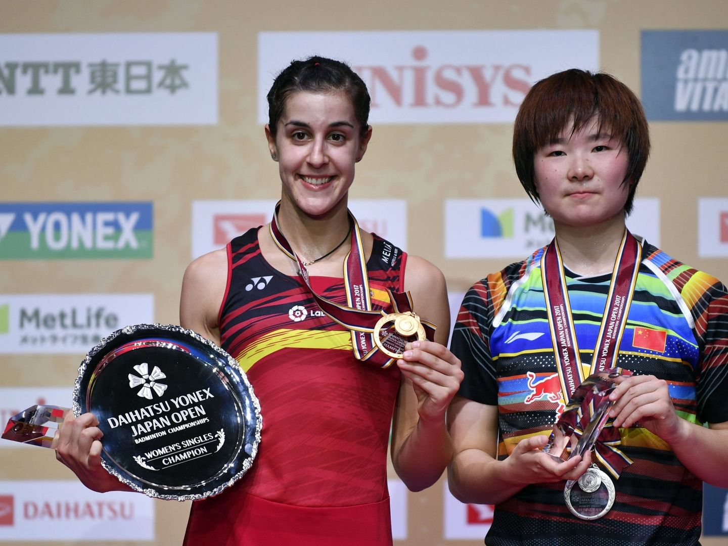 Carolina Marín y la china He Bingjiao, con sus trofeos en el podio del Superseries de Japón. (Reuters)