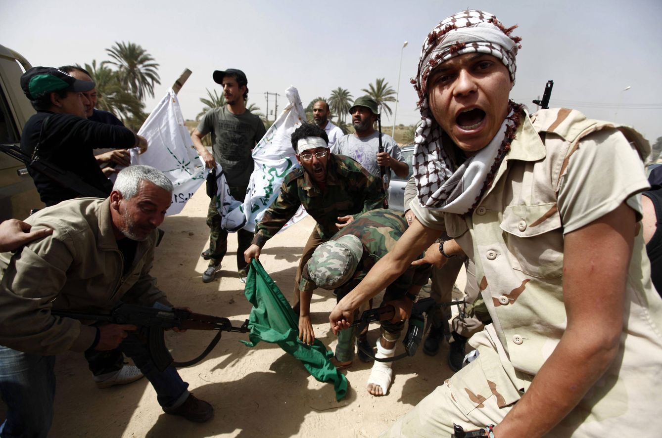 Combatientes revolucionarios libios rompen una bandera verde del régimen de Gadafi en Regdalin, en abril de 2012. (Reuters)