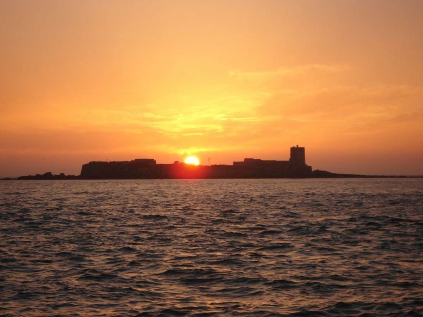 Puesta de sol en Sancti Petri con isla y castillo. (Foto: Patronato Provincial de Turismo de Cádiz)