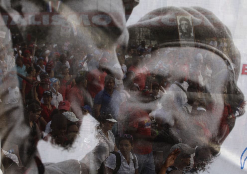 Foto: Cubanos tras un póster de Fidel Castro y el Ché Guevara (Reuters)