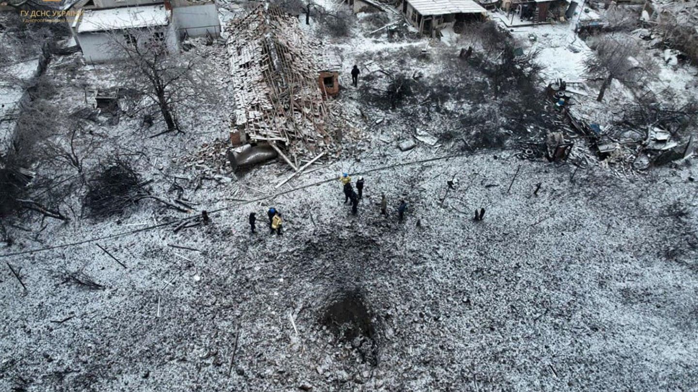 People stand next to a destroyed residential house and a crater at the site of a Russian missile strike, amid Russia's attack on Ukraine, in Dnipropetrovsk Region, Ukraine January 8, 2024. Press service of the State Emergency Service of Ukraine in Dnipropetrovsk region Handout via REUTERS ATTENTION EDITORS - THIS IMAGE HAS BEEN SUPPLIED BY A THIRD PARTY.
