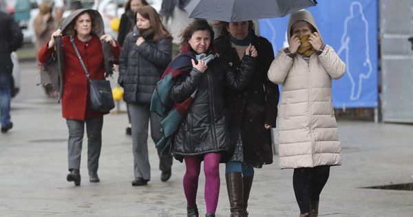 Foto:  Varias personas se protegen del frío en una céntrica calle de Madrid. (EFE)