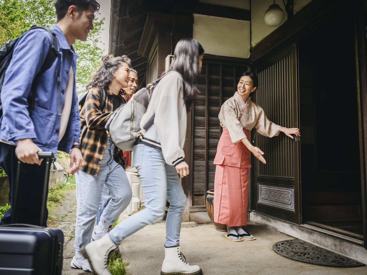 Un grupo de jóvenes japoneses llegando a una posada tradicional (iStock)