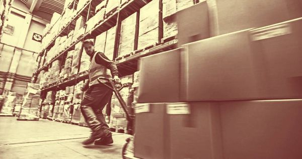Foto:  Un hombre mueve cajas en un almacen. (iStock)