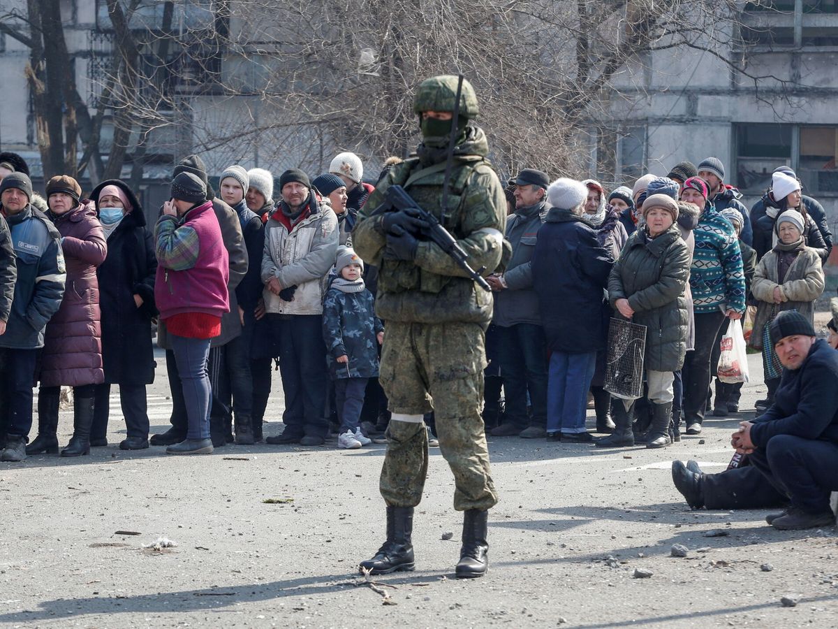 Foto: Un soldado ruso frente a un grupo de civiles en Mariúpol. (Reuters/Alexander Ermochenko)