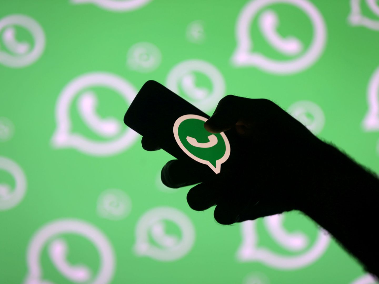 FILE PHOTO: A man poses with a smartphone in front of displayed Whatsapp logo in this illustration September 14, 2017. REUTERS Dado Ruvic File Photo
