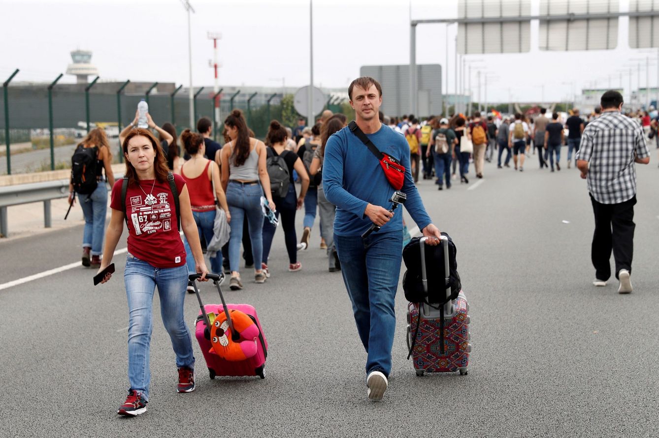 La gente acude con sus maletas a pie al aeropuerto. (EFE)