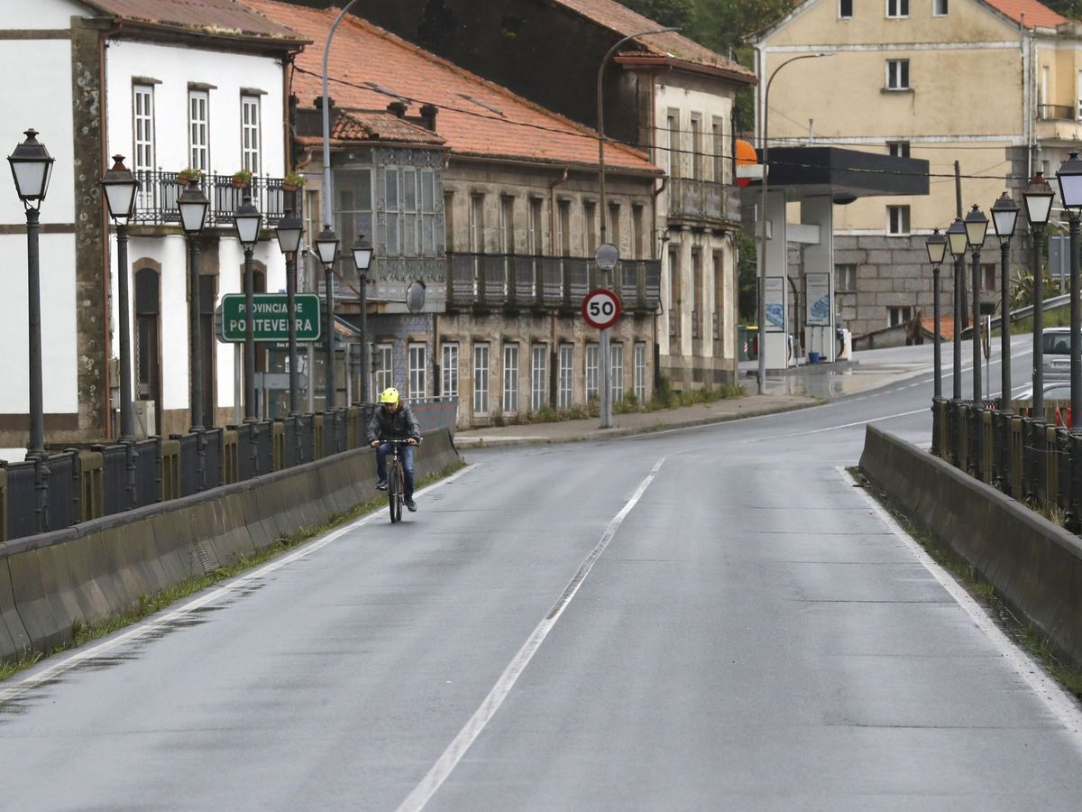 Foto: Un vecino de Pontecesures pasa hacia Padrón. (EFE)