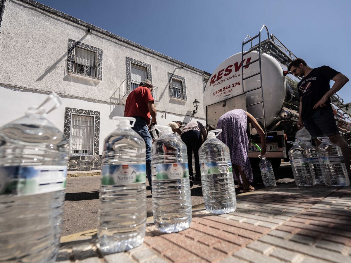 Foto: Varias personas recogen agua potable de un camión cisterna en la localidad cordobesa de Peñarroya. (EFE/Rafa Alcaide)