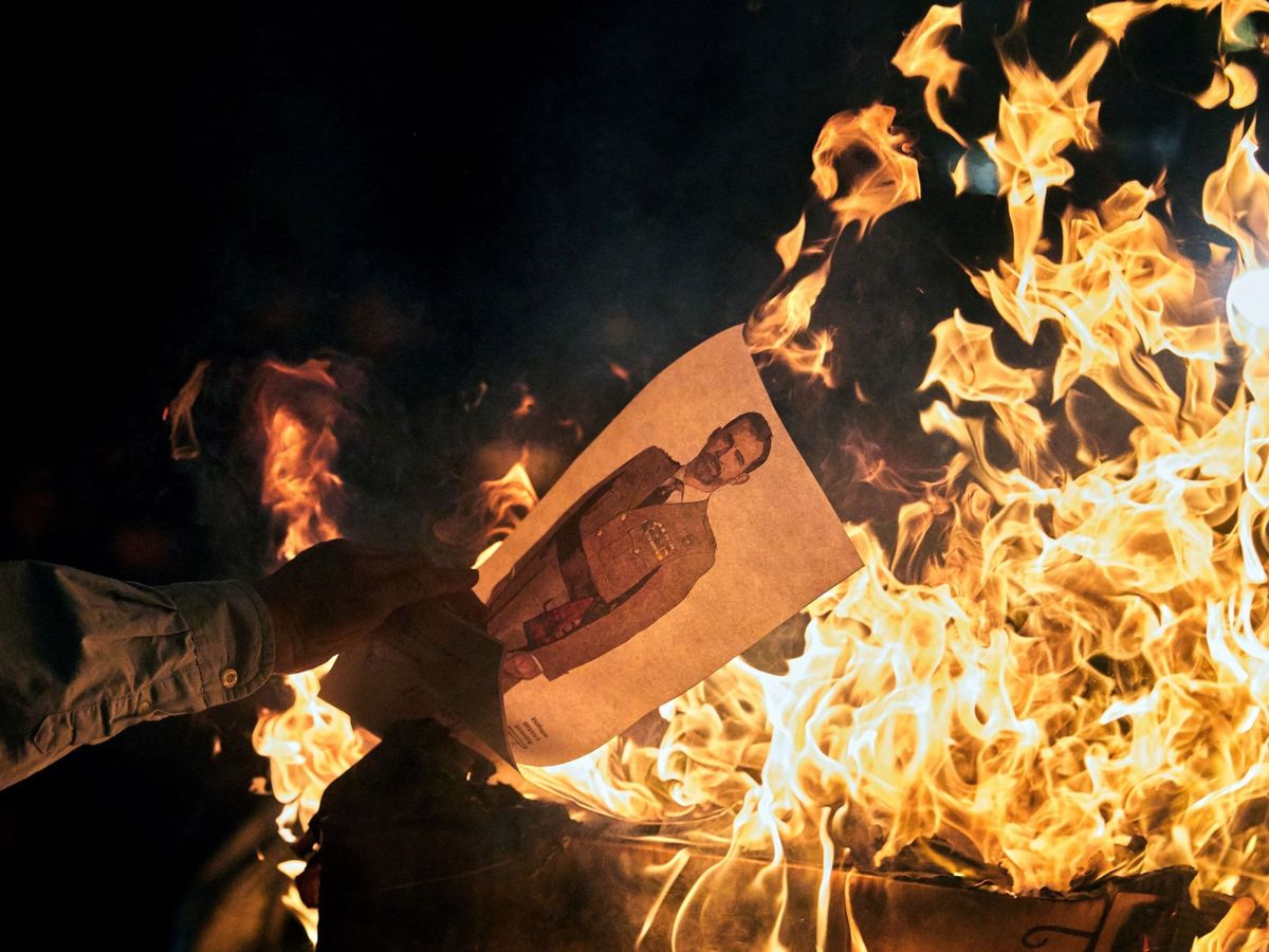 Foto: Varios manifestantes queman fotos del rey Felipe en una concentración convocada por los CDR en Girona. (EFE)