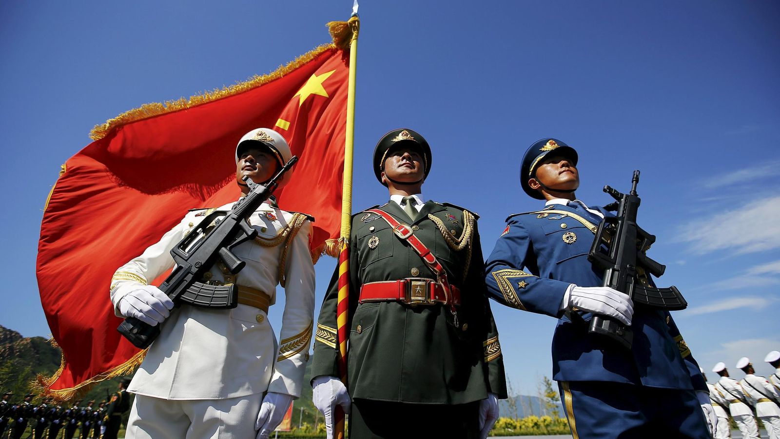 Foto: Oficiales y soldados del Ejército Popular de China sostienen una bandera durante los ensayos para un desfile conmemorativo en una base de Pekín (Reuters).