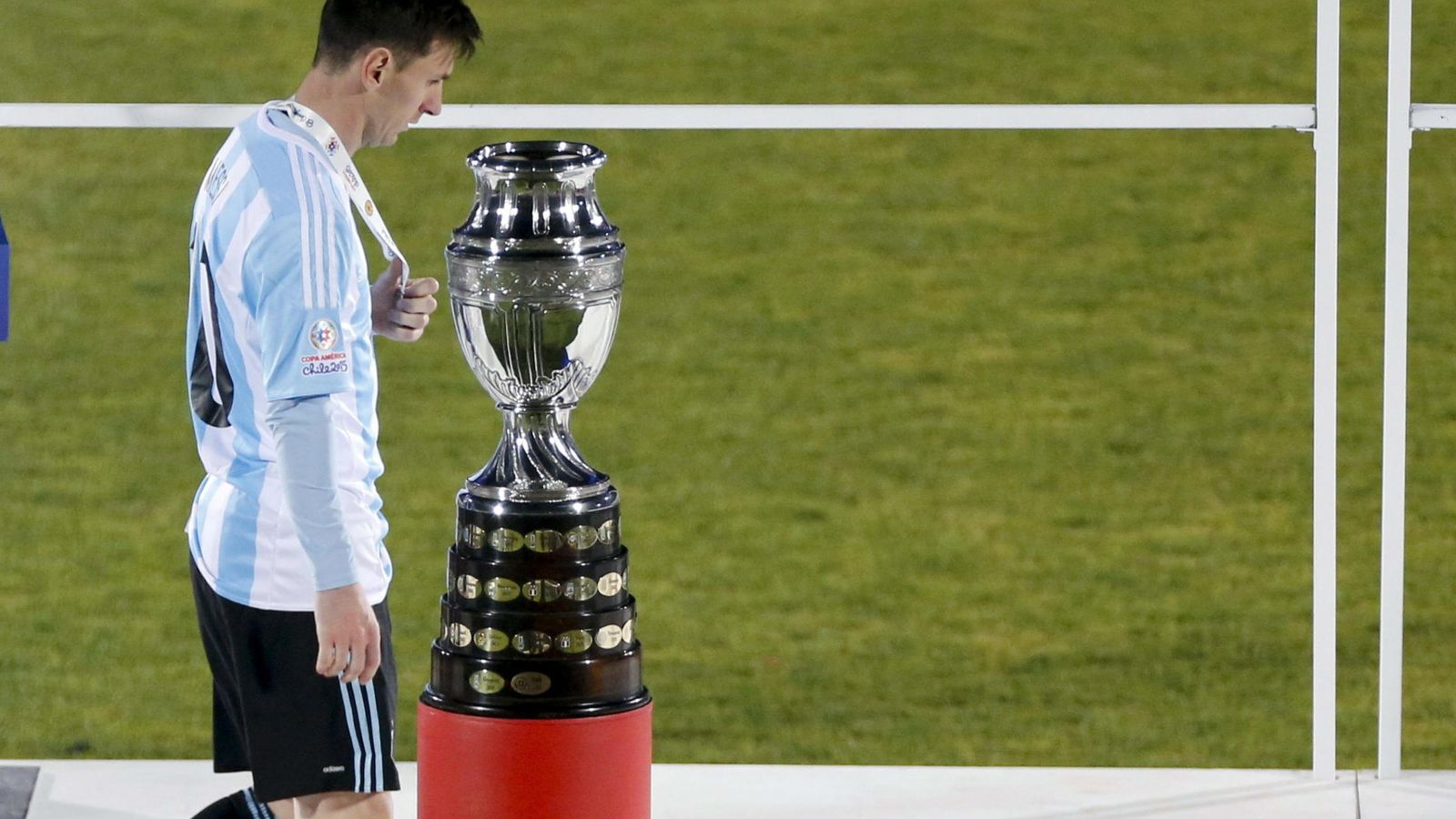 Foto: Messi pasa delante del trofeo que se llevó Chile al proclamarse campeón de la Copa América (EFE)