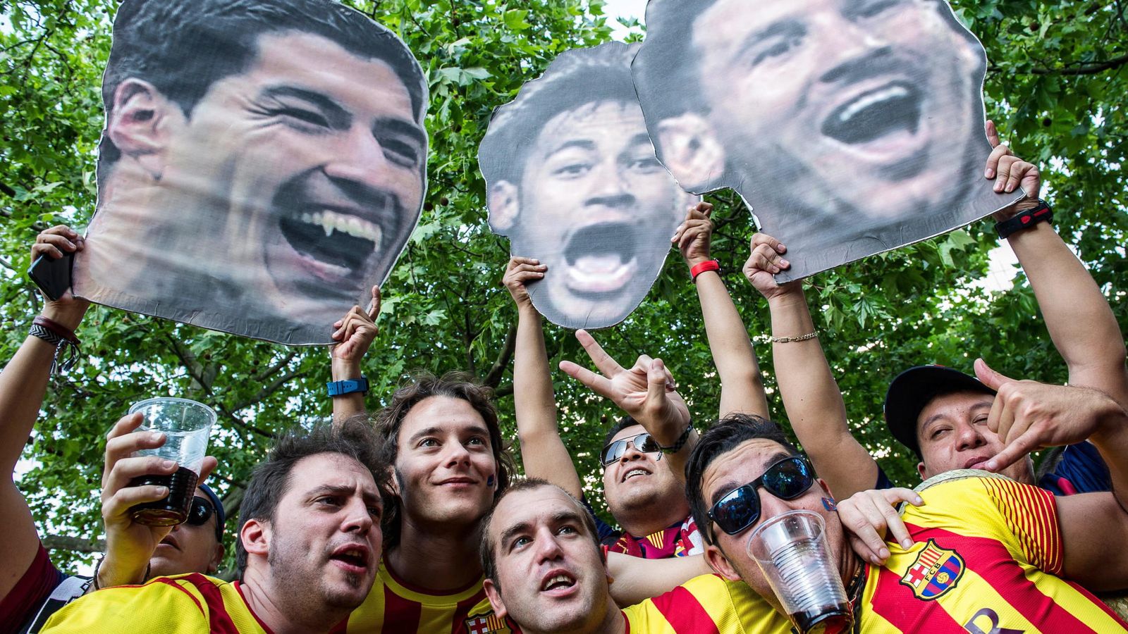Foto: Aficionados del Barça con imágenes de Luis Suárez, Neymar y Messi. (EFE)
